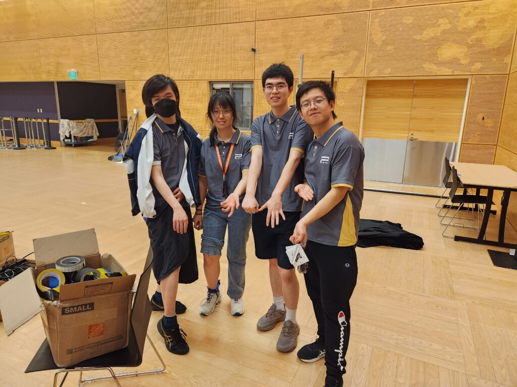 Team members showing competition wear and robot scars.