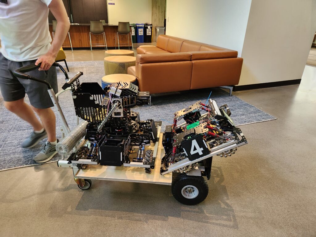Team members taking robots to the pit area.