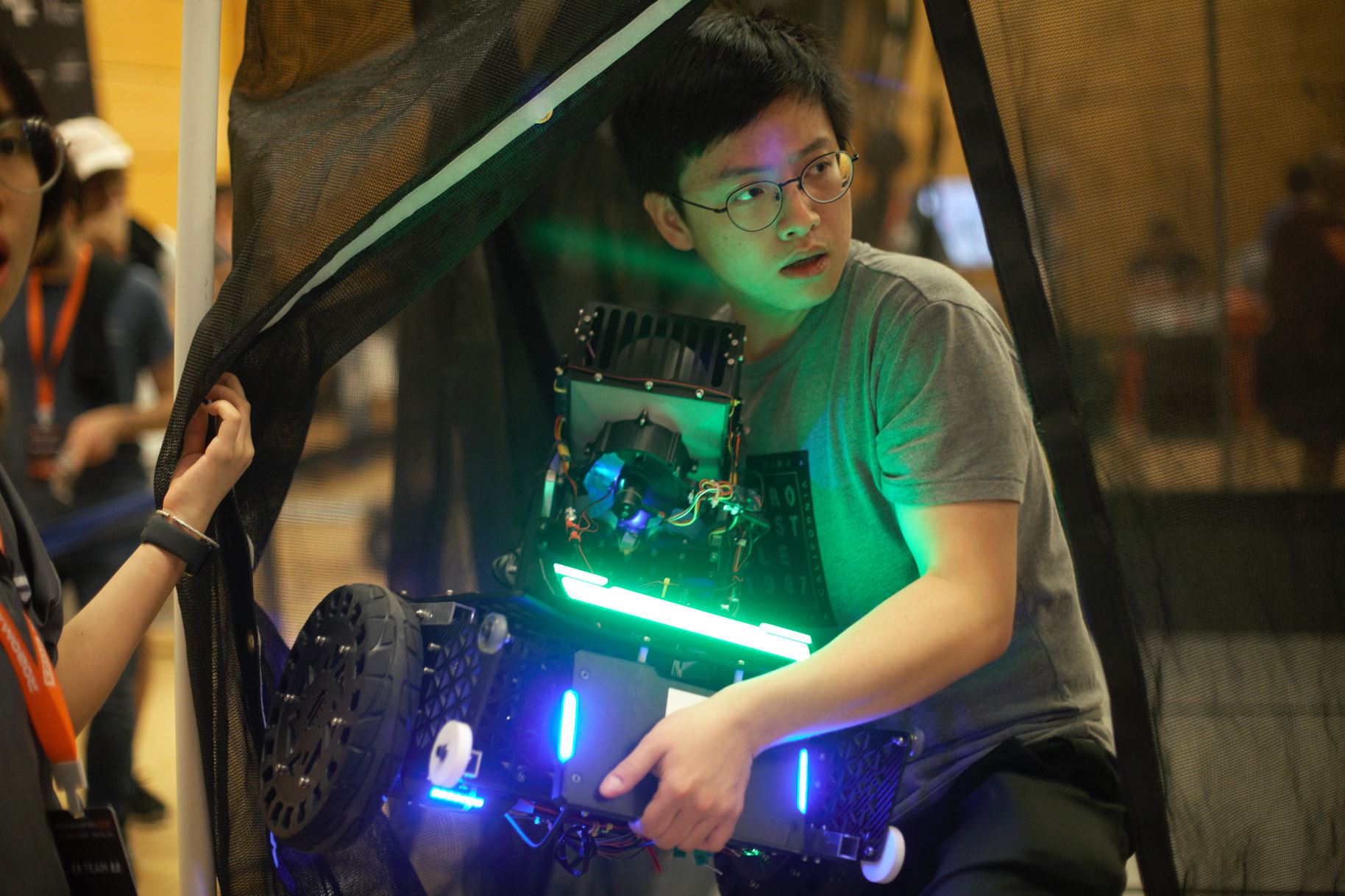 Yuxi Liu working with a RoboMaster robot at the 2023 Seattle competition.