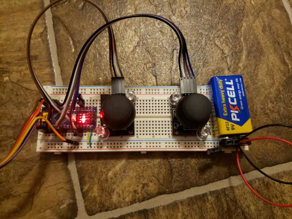 Breadboard joystick remote controller connected to a battery.